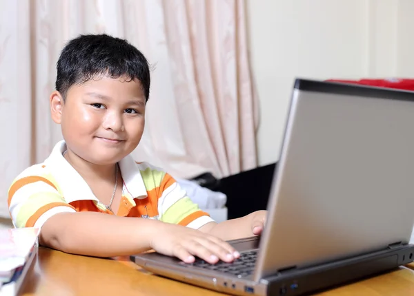 Asian boy was playing with my notebook — Stock Photo, Image