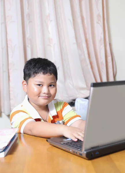 Asian boy was playing with my notebook — Stock Photo, Image