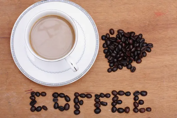 Kaffeebohnen mit Kaffee. Holz Hintergrund — Stockfoto