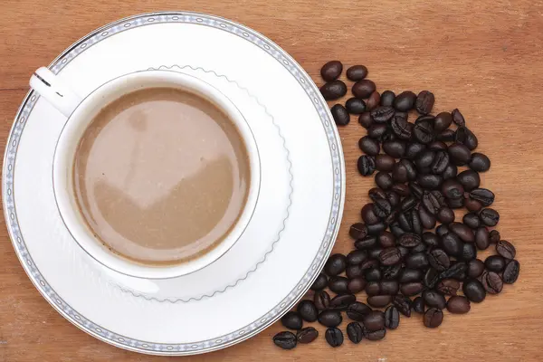 Kaffeebohnen mit Kaffee. Holz Hintergrund — Stockfoto
