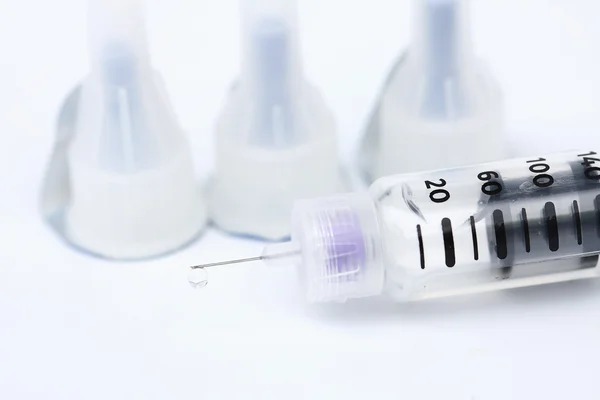 Druppels op het puntje van de injectiespuit op een witte achtergrond — Stockfoto
