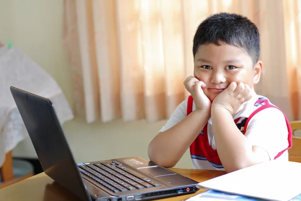 The boy was playing with my notebook. — Stock Photo, Image