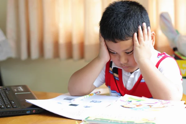 Le garçon travaille soigneusement ses devoirs . — Photo