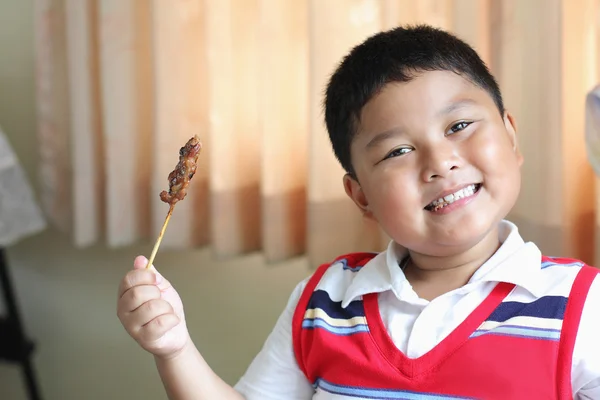 おいしい豚肉を食べる少年. — ストック写真