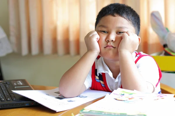 de jongen moe van huiswerk.