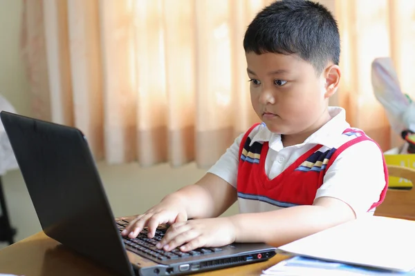 The boy was playing with my notebook. — Stock Photo, Image