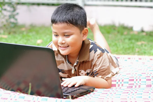 Un chico jugando al portátil. Felizmente. . — Foto de Stock