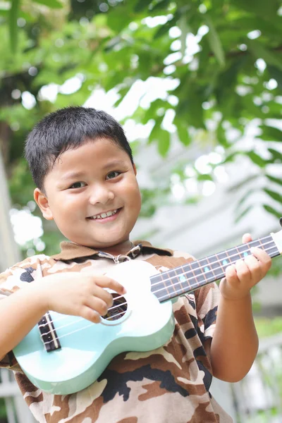 男孩玩的夏威夷四弦琴的乐趣. — 图库照片