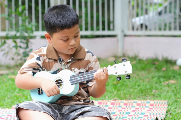 Boy playing the ukulele fun. — Stock Photo, Image