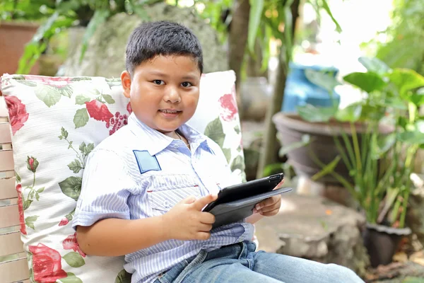 Asiatic băiat joc tabletă la the parc — Fotografie, imagine de stoc