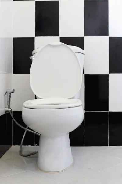 White toilet bowl in the bathroom. Alternating black and white t — Stock Photo, Image
