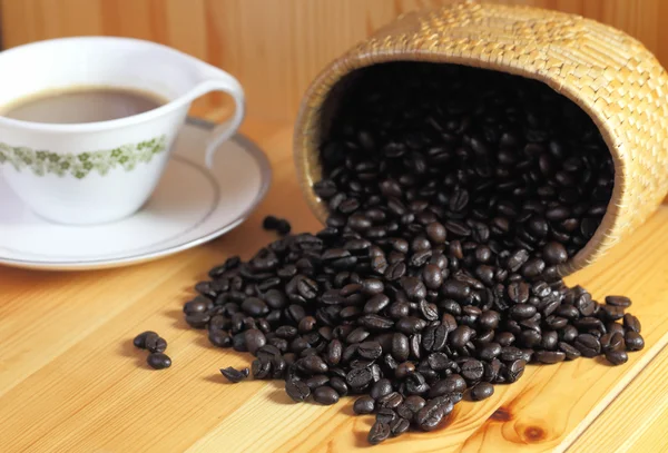 Tasse à café et grains de café sur une table en bois — Photo