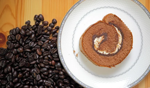 Rolo de geléia e grãos de café em madeira — Fotografia de Stock