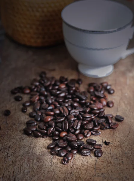 Taza de café y grano de café en una mesa de madera — Foto de Stock