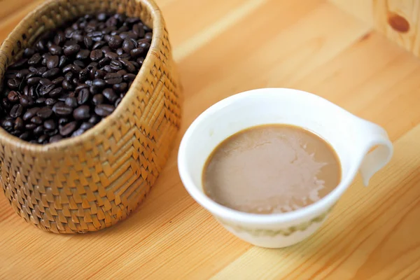 Xícara de café e café em uma mesa de madeira — Fotografia de Stock