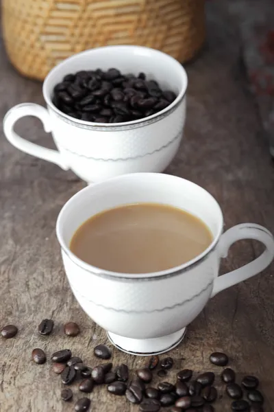 Xícara de café e café em uma mesa de madeira — Fotografia de Stock