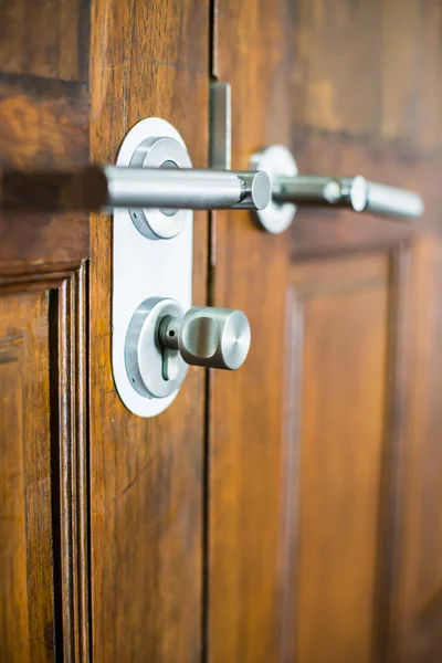 Poignée de porte chromée moderne sur une porte en bois — Photo