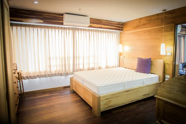Dormitorio interior con ropa de cama blanca y suelo de madera — Foto de Stock