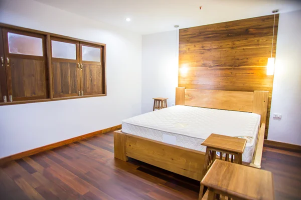 Dormitorio interior con ropa de cama blanca y suelo de madera Imagen de archivo