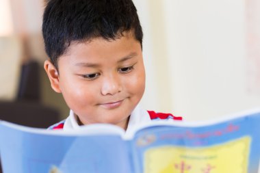 sevimli küçük oğlan masada okuma