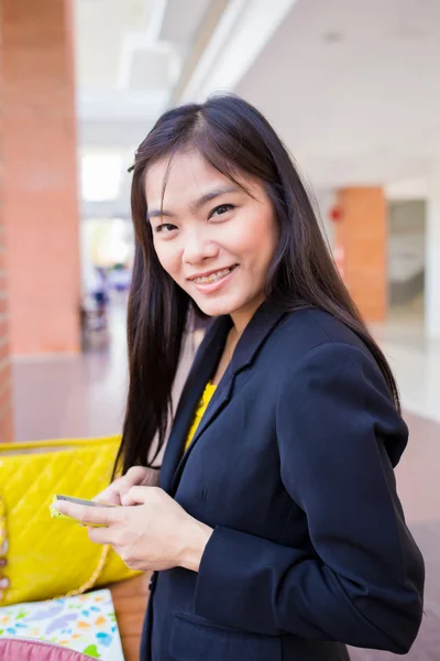 Vackra unga asiatiska affärskvinnor med en smart telefon på bil — Stockfoto