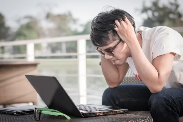 Asiatische Männer, die Computer benutzen, sind gestresst — Stockfoto