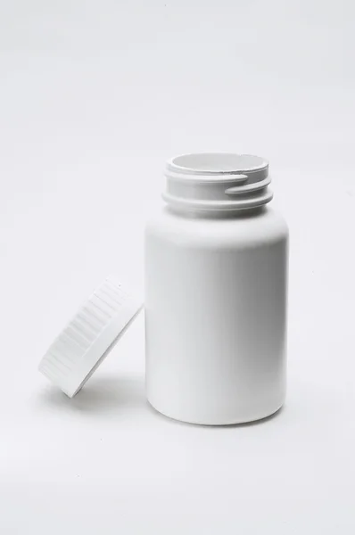 Відкрита біла пластикова пляшка таблеток — стокове фото