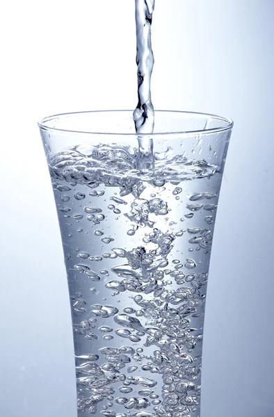 Pour clean water into one glass — Stock Photo, Image