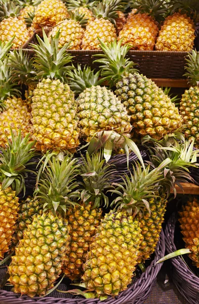 Många ananas i fästet, på marknaden Royaltyfria Stockfoton