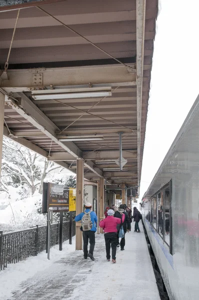Stazione ferroviaria vista con treno e persone, nevicando in inverno  , — Foto Stock