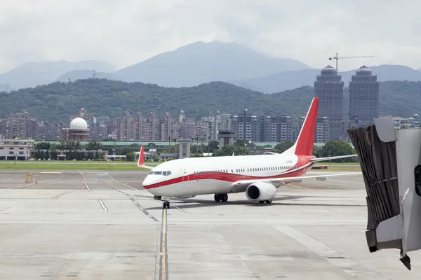 Aproximando-se de aeronaves com jetbridge em Taipei SongShan Aeroporto — Fotografia de Stock