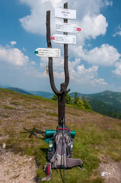 Martwa natura w górach z trek znak i plecak. — Zdjęcie stockowe