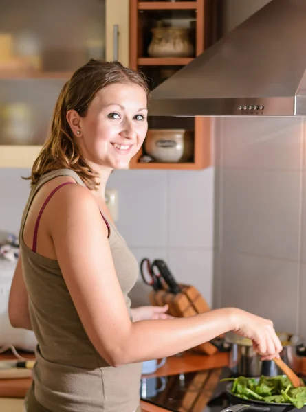 Lächelnde und fröhliche Frau beim Kochen — Stockfoto