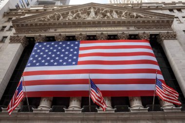 New York City, NY - February 16, 2009: A giant United States flag covers the columns of the New York Stock Exchange building.  clipart