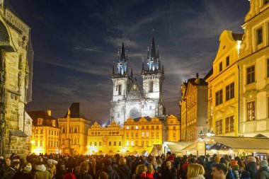 Prag 'daki eski şehir meydanı, Çek Cumhuriyeti' nin gece yarısı dramatik gökyüzü ile güzel bir imaj oluşturan bir kalabalık..