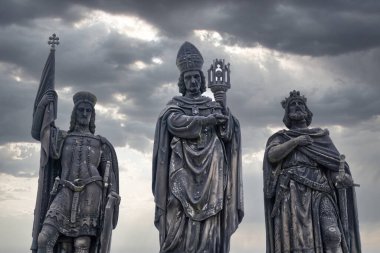 Prag 'daki Charles Köprüsü' nün heykelleri, Çek Cumhuriyeti 'nin akşam fotoğrafında arka planda dramatik bir gökyüzü.