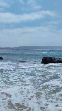Atlantic ocean shoreline of the Nazare beach in Portugal short vertical video