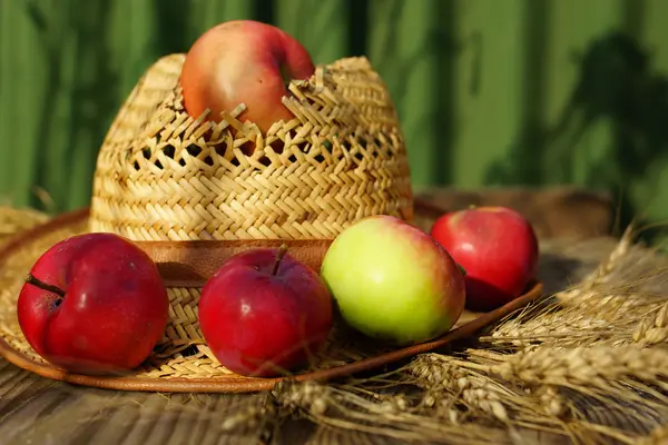 Elma, buğday ve hasır şapka — Stok fotoğraf