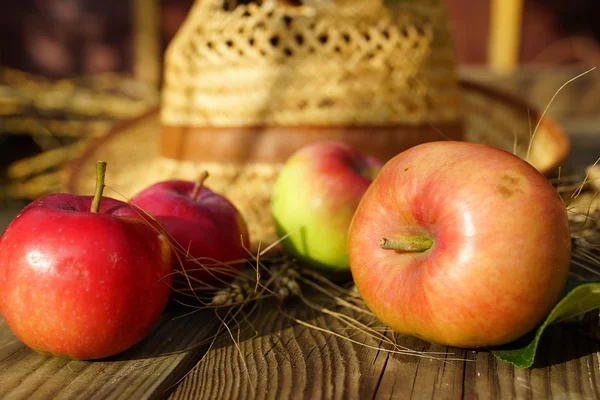 Appels, tarwe en stro hoed — Stockfoto
