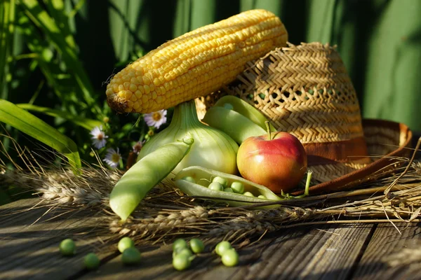 Composición rural con guisantes, maíz y sombrero de paja — Foto de Stock