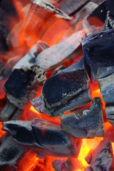Queimando e brilhando carvão e chama no churrasco — Fotografia de Stock