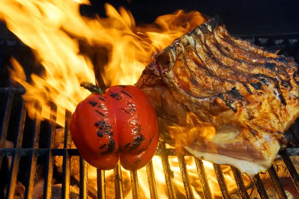 Ribben met groenten in de vlam op de grill — Stockfoto