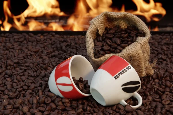Dwie filiżanki espresso i kawa na tle ognia — Zdjęcie stockowe