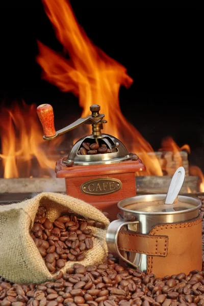 Roestvrij staal koffie mok en oude grinder met bonen Stockfoto