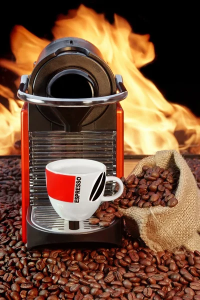 Coffee machine with cup of espresso near fireplace — Stock Photo, Image