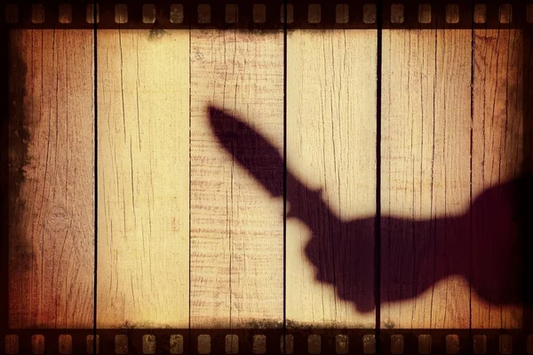 Silhueta de mão com faca no painel de madeira natural — Fotografia de Stock