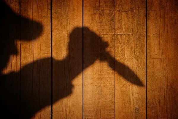 Silueta con cuchillo en el panel de madera natural —  Fotos de Stock