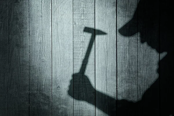 Schatten eines Mannes mit Hammer auf natürlichem Holzgrund — Stockfoto