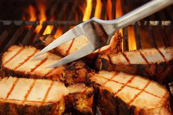 Filetes a la parrilla en la parrilla de barbacoa y llamas en el fondo, XXXL —  Fotos de Stock