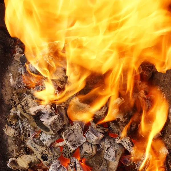 Burning Charcoal close-up in BBQ and Flames in background